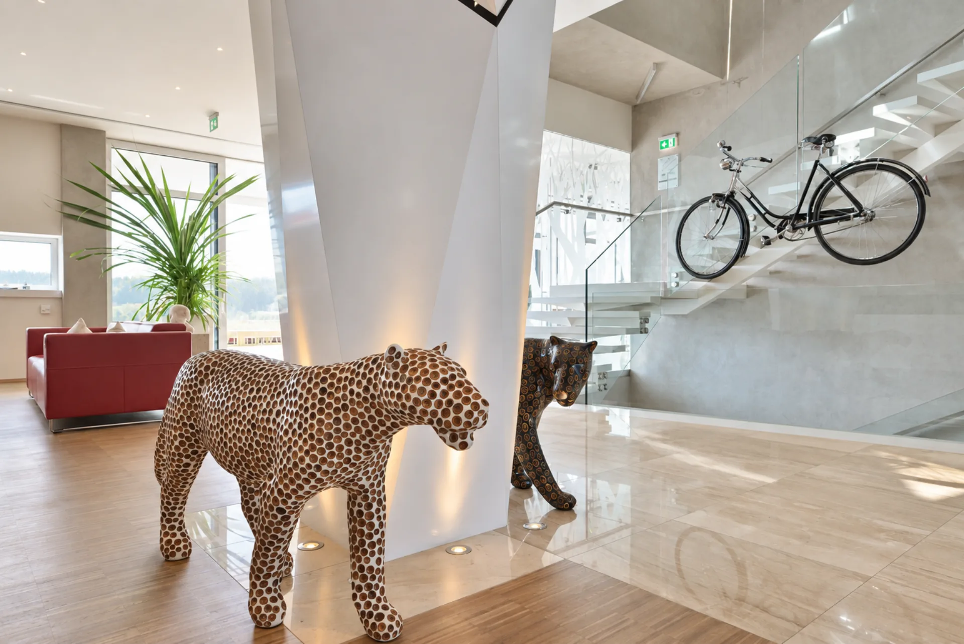 Moderní lobby Hotelu Antonie ve Frýdlantu s designovými sochami a zavěšeným kolem.