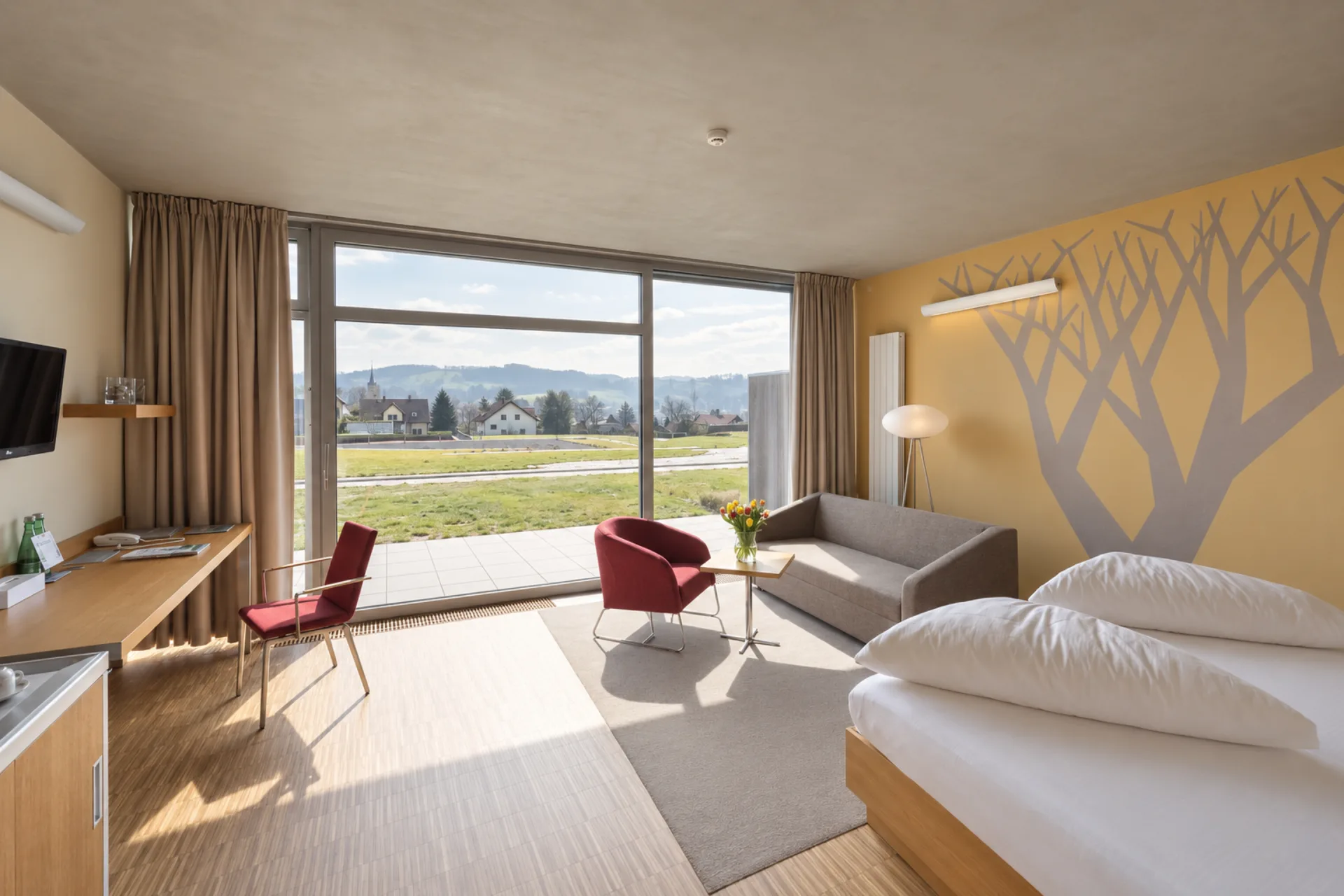 Prostorný pokoj Hotelu Antonie s posezením, terasou a výhledem do okolní krajiny.