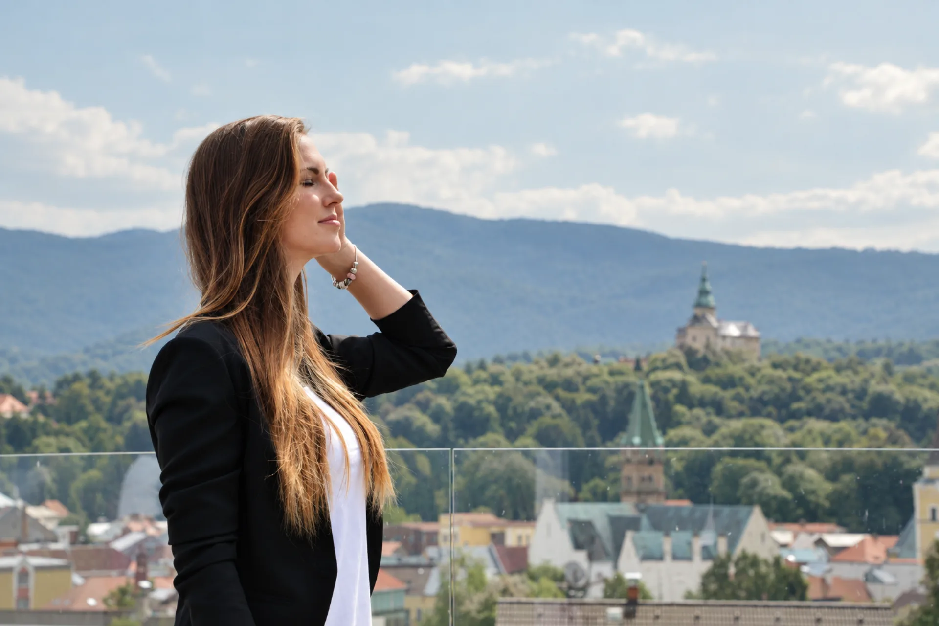 Žena na terase Hotelu Antonie s výhledem na Frýdlant a okolní krajinu Jizerských hor.