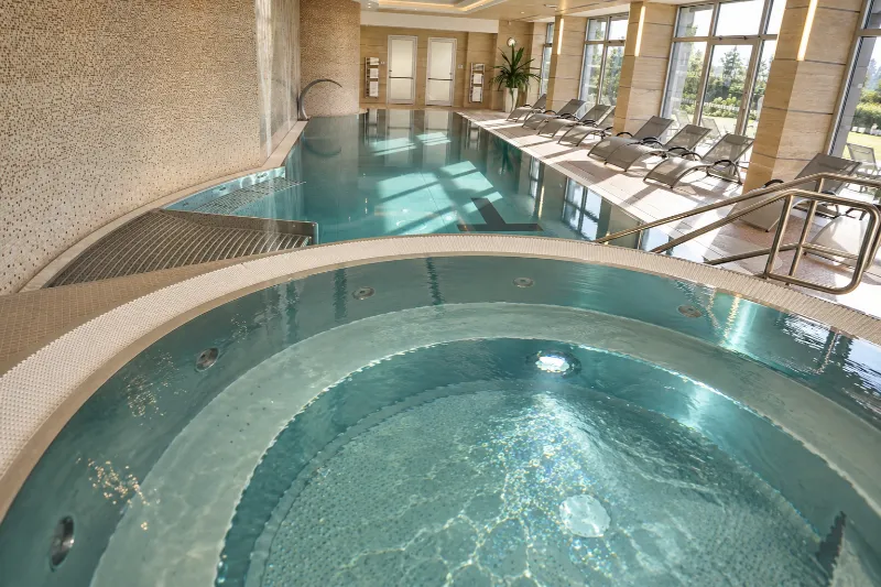 Interiér wellness Hotelu Antonie s krytým bazénem, vířivkou a moderním relaxačním prostorem.