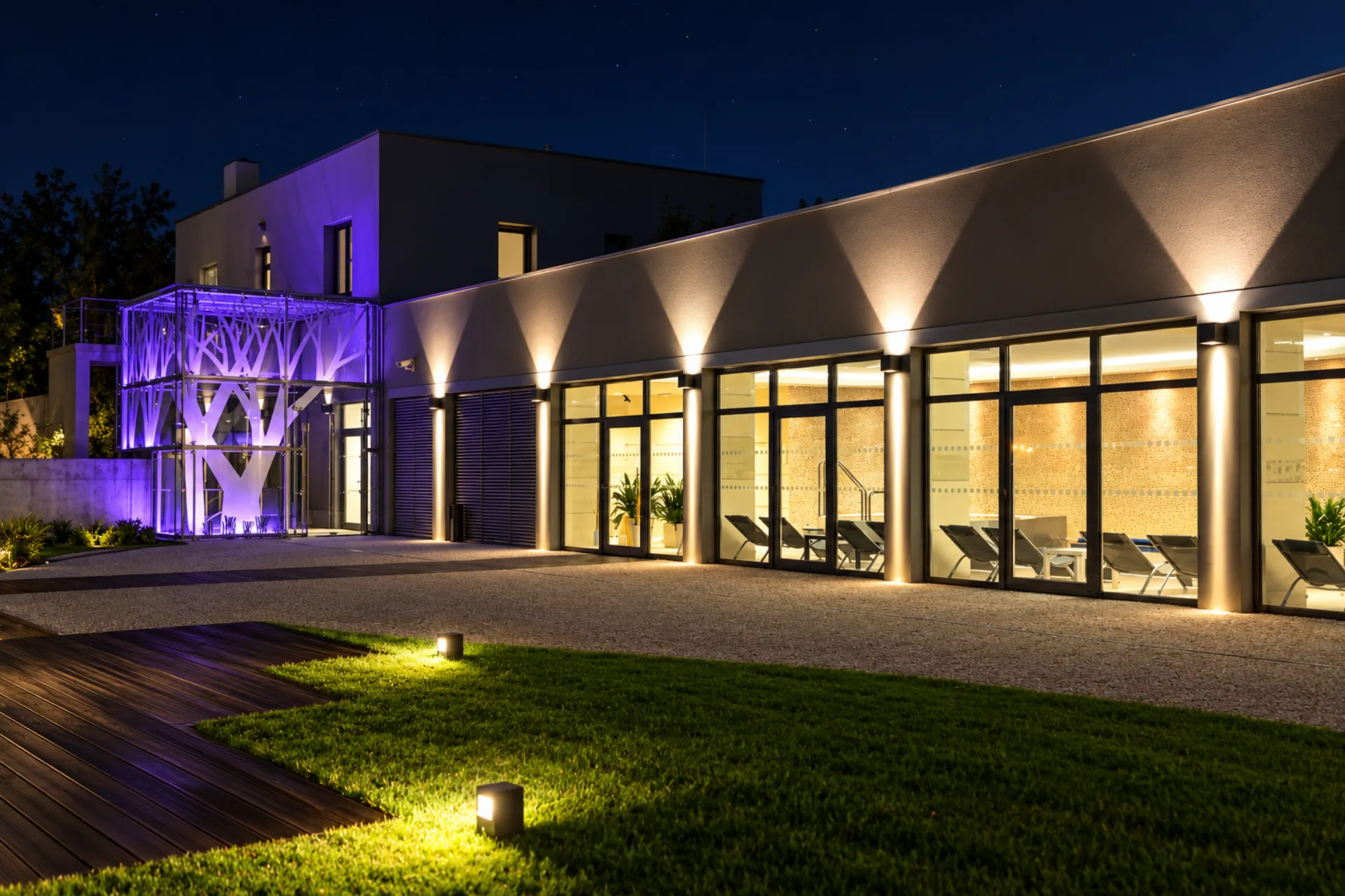 Noční pohled na osvětlené wellness Hotelu Antonie ve Frýdlantu s prosklenou fasádou a relaxační zónou.