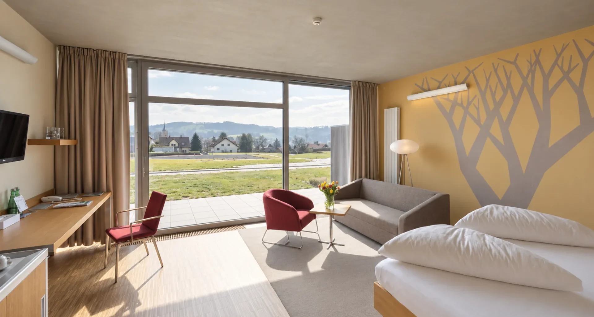 Prostorný pokoj Hotelu Antonie s posezením, terasou a výhledem do okolní krajiny.