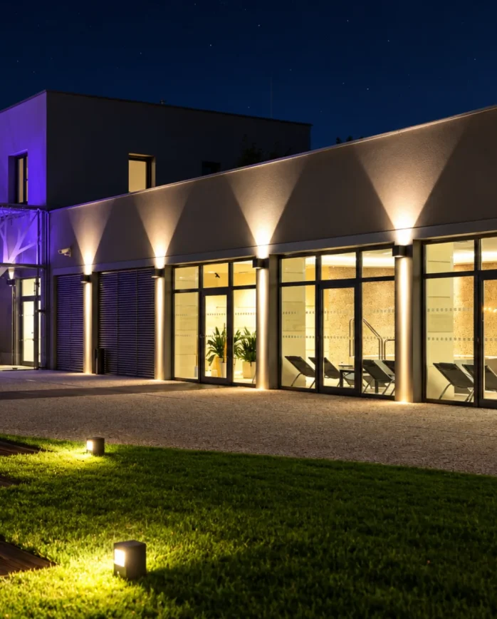 Noční pohled na osvětlené wellness Hotelu Antonie ve Frýdlantu s prosklenou fasádou a relaxační zónou.