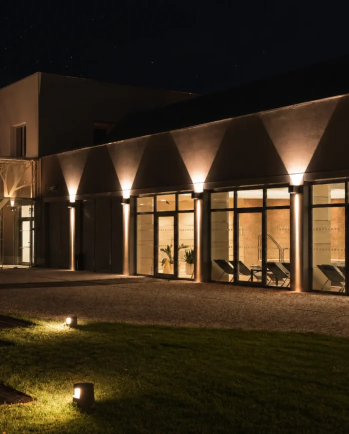 Noční pohled na osvětlené wellness Hotelu Antonie ve Frýdlantu s prosklenou fasádou a relaxační zónou.