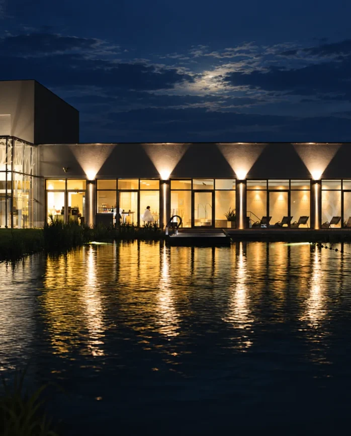 Nočně osvětlené wellness Hotelu Antonie ve Frýdlantu s prosklenou fasádou a nasvíceným exteriérem.